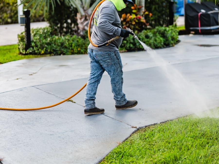 Backpack sprayer applying treatment with visible spray pattern