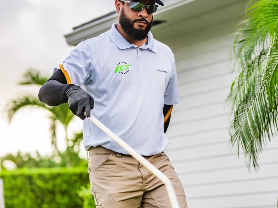 East Coast Sprayers technician in branded polo working mid-treatment